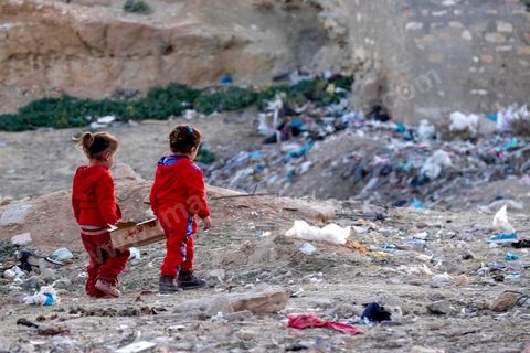 27 janvier 2016 : les poubelles sont le terrain de jeu quotidien des plus jeunes enfants, deux jeunes filles ramassent les sachets vides des biscuits pour enfants. Quartier populaire et deshérité de Karma sur les hauteurs de Kasserine. Ici la population vit au milieu des poubelles, construit leurs maison de façon anarchiques jusque dans les oueds. Les familles vivent entassés dans des maisons certes en dure mais dans la plus grande précarité, pas de fenêtres, pas de portes, pas de chauffage et d'eau pour certains. 