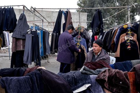 28 janvier 2016 : derrière la rue principale du centre de Kasserine, chaque jour des femmes et des hommes bravent à la première heure du jour le froid pour s'assurer une place sur ce terrain vague pour vendre des frippes. La situation extrémement précaire de très nombreuses familles de la ville et de la région poussent les gens à développer des marchés parallèles. 