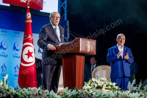 20 mai 2016 : Discours de  Béji Caïd Essebsi avec au fond Rached Ghannouchi à l'ouverture du 10e congrès du Mouvement Ennahdha dans la garnde salle de sport de Radès, avec plusierus milliers de militants et de congressistes du parti Ennahdha. Mais l'événement fut bien la présence et le discours de Beji Caïd Essebsi, Président de la République élu il y a plus d'un an grâce à une campagne anti Ennahdha, mais avec qui il doit depuis cohabiter au pouvoir : "Je veux être franc avec vous, j'ai hésité à venir", a-t-il dit. Mais "je suis venu par considération pour les efforts de ce parti pour appuyer le consensus de réconciliation nationale"La cérémonie inaugurale s’est déroulée en présence du président de l’Assemblée des représentants du peuple, Mohamed Ennaceur, des membres de la coalition gouvernementale, de partis représentés et non représentés au parlement, de députés et de personnalités nationales, un show où il était bon d'être vu. Ce congrès doit marquer un tournant dans l'histoire du mouvement en actant la séparation entre activités politiques et religieuses. Au cours du week-end, le parti - pour lequel un changement de nom est évoqué - doit évaluer son action et tirer le bilan de ses deux ans au pouvoir au sein d'une "troïka".Il doit aussi adopter des "feuilles de route" politique, économique et sociale pour les années à venir.