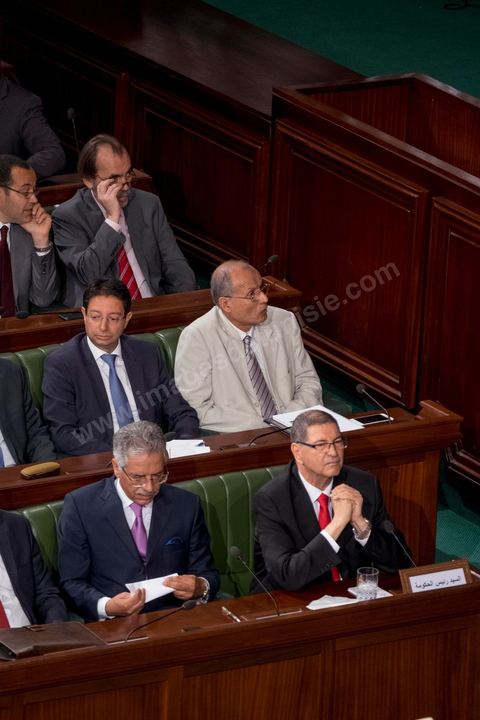30 juillet 2016 : Le banc des ministres du gouvernement de Habib Essid. Après dix-huit mois à la tête du gouvernement tunisien, Habib Essid, technocrate âgé de 67 ans, n’est plus le premier ministre. L’Assemblée des représentants du peuple (ARP), réunie samedi 30 juillet à Tunis, a refusé par 118 voix sur 148 (3 pour et 27 abstentions) de renouveler sa confiance à M. Essid, qui l’avait sollicitée sans trop se faire d’illusions sur l’issue du vote. L’essentiel des députés affiliés aux quatre partis (Nidaa Tounès, Ennahda, Afek Tounès et Union Patriotique Libre) associés à la coalition gouvernementale dirigée par M. Essid ont voté contre la reconduction du premier ministre.Le départ de ce dernier solde le conflit qui l’oppose depuis deux mois au président de la République Béji Caïd Essebsi, âgé de 89 ans. Le 2 juin, le chef de l’Etat avait fragilisé la position de M. Essid en lançant l’idée d’un gouvernement d’« union nationale », une initiative justifiée à ses yeux par la nécessité d’ouvrir une phase plus offensive de l’action gouvernementale. Alors que la Tunisie est confrontée à une économique et sociale très difficile.