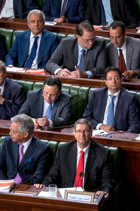 30 juillet 2016 : Le banc des ministres du gouvernement de Habib Essid. Après dix-huit mois à la tête du gouvernement tunisien, Habib Essid, technocrate âgé de 67 ans, n’est plus le premier ministre. L’Assemblée des représentants du peuple (ARP), réunie samedi 30 juillet à Tunis, a refusé par 118 voix sur 148 (3 pour et 27 abstentions) de renouveler sa confiance à M. Essid, qui l’avait sollicitée sans trop se faire d’illusions sur l’issue du vote. L’essentiel des députés affiliés aux quatre partis (Nidaa Tounès, Ennahda, Afek Tounès et Union Patriotique Libre) associés à la coalition gouvernementale dirigée par M. Essid ont voté contre la reconduction du premier ministre.Le départ de ce dernier solde le conflit qui l’oppose depuis deux mois au président de la République Béji Caïd Essebsi, âgé de 89 ans. Le 2 juin, le chef de l’Etat avait fragilisé la position de M. Essid en lançant l’idée d’un gouvernement d’« union nationale », une initiative justifiée à ses yeux par la nécessité d’ouvrir une phase plus offensive de l’action gouvernementale. Alors que la Tunisie est confrontée à une économique et sociale très difficile.