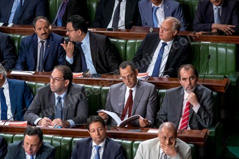 30 juillet 2016 : Le banc des ministres du gouvernement de Habib Essid. Après dix-huit mois à la tête du gouvernement tunisien, Habib Essid, technocrate âgé de 67 ans, n’est plus le premier ministre. L’Assemblée des représentants du peuple (ARP), réunie samedi 30 juillet à Tunis, a refusé par 118 voix sur 148 (3 pour et 27 abstentions) de renouveler sa confiance à M. Essid, qui l’avait sollicitée sans trop se faire d’illusions sur l’issue du vote. L’essentiel des députés affiliés aux quatre partis (Nidaa Tounès, Ennahda, Afek Tounès et Union Patriotique Libre) associés à la coalition gouvernementale dirigée par M. Essid ont voté contre la reconduction du premier ministre.Le départ de ce dernier solde le conflit qui l’oppose depuis deux mois au président de la République Béji Caïd Essebsi, âgé de 89 ans. Le 2 juin, le chef de l’Etat avait fragilisé la position de M. Essid en lançant l’idée d’un gouvernement d’« union nationale », une initiative justifiée à ses yeux par la nécessité d’ouvrir une phase plus offensive de l’action gouvernementale. Alors que la Tunisie est confrontée à une économique et sociale très difficile.