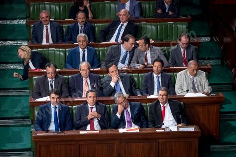 30 juillet 2016 : Le banc des ministres du gouvernement de Habib Essid. Après dix-huit mois à la tête du gouvernement tunisien, Habib Essid, technocrate âgé de 67 ans, n’est plus le premier ministre. L’Assemblée des représentants du peuple (ARP), réunie samedi 30 juillet à Tunis, a refusé par 118 voix sur 148 (3 pour et 27 abstentions) de renouveler sa confiance à M. Essid, qui l’avait sollicitée sans trop se faire d’illusions sur l’issue du vote. L’essentiel des députés affiliés aux quatre partis (Nidaa Tounès, Ennahda, Afek Tounès et Union Patriotique Libre) associés à la coalition gouvernementale dirigée par M. Essid ont voté contre la reconduction du premier ministre.Le départ de ce dernier solde le conflit qui l’oppose depuis deux mois au président de la République Béji Caïd Essebsi, âgé de 89 ans. Le 2 juin, le chef de l’Etat avait fragilisé la position de M. Essid en lançant l’idée d’un gouvernement d’« union nationale », une initiative justifiée à ses yeux par la nécessité d’ouvrir une phase plus offensive de l’action gouvernementale. Alors que la Tunisie est confrontée à une économique et sociale très difficile.