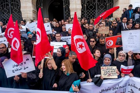 6 décémbre 2016 : Plus de 2.000 avocats ont manifesté mardi à Tunis contre les nouvelles dispositions fiscales qui leur ont été imposées dans le projet de budget 2017, actuellement examiné par le Parlement."Avec notre âme, avec notre sang nous défendrons le métier d'avocat", ont crié les manifestants en robe noire devant le siège du gouvernement à la Kasbah, dans le centre de Tunis, après une marche de quelques centaines de mètres."Les avocats sont en colère!", "Nous n'allons pas financer votre corruption", pouvait-on lire sur des pancartes brandies par les protestataires, dont beaucoup jugent les nouvelles mesures "injustes" et "inapplicables".En cause, des taxes imposées pour chaque dossier traité, pouvant être déduites de l'impôt sur le revenu et prévues dans le projet de loi de finances 2017.Ce mouvement ne fait toutefois pas l'unanimité, et sur les réseaux sociaux comme dans certains médias, les protestations des avocats ont été considérées comme une volonté de bénéficier d'un traitement spécial. Selon le webzine Inkyfada, qui a analysé des données officielles, 60% des avocats enregistrés n'ont pas déclaré d'impôts en 2015, et "les avocats en règle paient en moyenne 228 dinars (92 euros) d'impôt sur le revenu par mois".