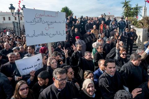 6 décémbre 2016 : Plus de 2.000 avocats ont manifesté mardi à Tunis contre les nouvelles dispositions fiscales qui leur ont été imposées dans le projet de budget 2017, actuellement examiné par le Parlement."Avec notre âme, avec notre sang nous défendrons le métier d'avocat", ont crié les manifestants en robe noire devant le siège du gouvernement à la Kasbah, dans le centre de Tunis, après une marche de quelques centaines de mètres."Les avocats sont en colère!", "Nous n'allons pas financer votre corruption", pouvait-on lire sur des pancartes brandies par les protestataires, dont beaucoup jugent les nouvelles mesures "injustes" et "inapplicables".En cause, des taxes imposées pour chaque dossier traité, pouvant être déduites de l'impôt sur le revenu et prévues dans le projet de loi de finances 2017.Ce mouvement ne fait toutefois pas l'unanimité, et sur les réseaux sociaux comme dans certains médias, les protestations des avocats ont été considérées comme une volonté de bénéficier d'un traitement spécial. Selon le webzine Inkyfada, qui a analysé des données officielles, 60% des avocats enregistrés n'ont pas déclaré d'impôts en 2015, et "les avocats en règle paient en moyenne 228 dinars (92 euros) d'impôt sur le revenu par mois".