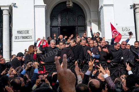 6 décémbre 2016 : Plus de 2.000 avocats ont manifesté mardi à Tunis contre les nouvelles dispositions fiscales qui leur ont été imposées dans le projet de budget 2017, actuellement examiné par le Parlement."Avec notre âme, avec notre sang nous défendrons le métier d'avocat", ont crié les manifestants en robe noire devant le siège du gouvernement à la Kasbah, dans le centre de Tunis, après une marche de quelques centaines de mètres."Les avocats sont en colère!", "Nous n'allons pas financer votre corruption", pouvait-on lire sur des pancartes brandies par les protestataires, dont beaucoup jugent les nouvelles mesures "injustes" et "inapplicables".En cause, des taxes imposées pour chaque dossier traité, pouvant être déduites de l'impôt sur le revenu et prévues dans le projet de loi de finances 2017.Ce mouvement ne fait toutefois pas l'unanimité, et sur les réseaux sociaux comme dans certains médias, les protestations des avocats ont été considérées comme une volonté de bénéficier d'un traitement spécial. Selon le webzine Inkyfada, qui a analysé des données officielles, 60% des avocats enregistrés n'ont pas déclaré d'impôts en 2015, et "les avocats en règle paient en moyenne 228 dinars (92 euros) d'impôt sur le revenu par mois".