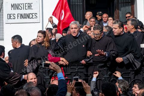 6 décémbre 2016 : Plus de 2.000 avocats ont manifesté mardi à Tunis contre les nouvelles dispositions fiscales qui leur ont été imposées dans le projet de budget 2017, actuellement examiné par le Parlement."Avec notre âme, avec notre sang nous défendrons le métier d'avocat", ont crié les manifestants en robe noire devant le siège du gouvernement à la Kasbah, dans le centre de Tunis, après une marche de quelques centaines de mètres."Les avocats sont en colère!", "Nous n'allons pas financer votre corruption", pouvait-on lire sur des pancartes brandies par les protestataires, dont beaucoup jugent les nouvelles mesures "injustes" et "inapplicables".En cause, des taxes imposées pour chaque dossier traité, pouvant être déduites de l'impôt sur le revenu et prévues dans le projet de loi de finances 2017.Ce mouvement ne fait toutefois pas l'unanimité, et sur les réseaux sociaux comme dans certains médias, les protestations des avocats ont été considérées comme une volonté de bénéficier d'un traitement spécial. Selon le webzine Inkyfada, qui a analysé des données officielles, 60% des avocats enregistrés n'ont pas déclaré d'impôts en 2015, et "les avocats en règle paient en moyenne 228 dinars (92 euros) d'impôt sur le revenu par mois".