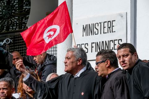 6 décémbre 2016 : Plus de 2.000 avocats ont manifesté mardi à Tunis contre les nouvelles dispositions fiscales qui leur ont été imposées dans le projet de budget 2017, actuellement examiné par le Parlement."Avec notre âme, avec notre sang nous défendrons le métier d'avocat", ont crié les manifestants en robe noire devant le siège du gouvernement à la Kasbah, dans le centre de Tunis, après une marche de quelques centaines de mètres."Les avocats sont en colère!", "Nous n'allons pas financer votre corruption", pouvait-on lire sur des pancartes brandies par les protestataires, dont beaucoup jugent les nouvelles mesures "injustes" et "inapplicables".En cause, des taxes imposées pour chaque dossier traité, pouvant être déduites de l'impôt sur le revenu et prévues dans le projet de loi de finances 2017.Ce mouvement ne fait toutefois pas l'unanimité, et sur les réseaux sociaux comme dans certains médias, les protestations des avocats ont été considérées comme une volonté de bénéficier d'un traitement spécial. Selon le webzine Inkyfada, qui a analysé des données officielles, 60% des avocats enregistrés n'ont pas déclaré d'impôts en 2015, et "les avocats en règle paient en moyenne 228 dinars (92 euros) d'impôt sur le revenu par mois".
