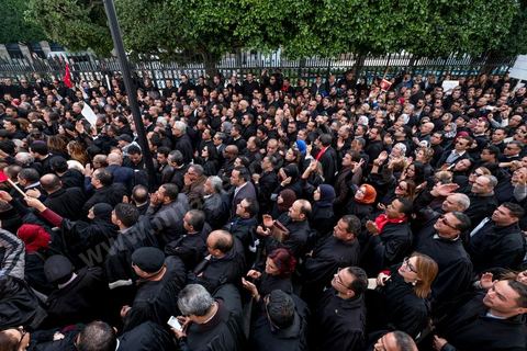 6 décémbre 2016 : Plus de 2.000 avocats ont manifesté mardi à Tunis contre les nouvelles dispositions fiscales qui leur ont été imposées dans le projet de budget 2017, actuellement examiné par le Parlement."Avec notre âme, avec notre sang nous défendrons le métier d'avocat", ont crié les manifestants en robe noire devant le siège du gouvernement à la Kasbah, dans le centre de Tunis, après une marche de quelques centaines de mètres."Les avocats sont en colère!", "Nous n'allons pas financer votre corruption", pouvait-on lire sur des pancartes brandies par les protestataires, dont beaucoup jugent les nouvelles mesures "injustes" et "inapplicables".En cause, des taxes imposées pour chaque dossier traité, pouvant être déduites de l'impôt sur le revenu et prévues dans le projet de loi de finances 2017.Ce mouvement ne fait toutefois pas l'unanimité, et sur les réseaux sociaux comme dans certains médias, les protestations des avocats ont été considérées comme une volonté de bénéficier d'un traitement spécial. Selon le webzine Inkyfada, qui a analysé des données officielles, 60% des avocats enregistrés n'ont pas déclaré d'impôts en 2015, et "les avocats en règle paient en moyenne 228 dinars (92 euros) d'impôt sur le revenu par mois".