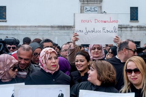 6 décémbre 2016 : Plus de 2.000 avocats ont manifesté mardi à Tunis contre les nouvelles dispositions fiscales qui leur ont été imposées dans le projet de budget 2017, actuellement examiné par le Parlement."Avec notre âme, avec notre sang nous défendrons le métier d'avocat", ont crié les manifestants en robe noire devant le siège du gouvernement à la Kasbah, dans le centre de Tunis, après une marche de quelques centaines de mètres."Les avocats sont en colère!", "Nous n'allons pas financer votre corruption", pouvait-on lire sur des pancartes brandies par les protestataires, dont beaucoup jugent les nouvelles mesures "injustes" et "inapplicables".En cause, des taxes imposées pour chaque dossier traité, pouvant être déduites de l'impôt sur le revenu et prévues dans le projet de loi de finances 2017.Ce mouvement ne fait toutefois pas l'unanimité, et sur les réseaux sociaux comme dans certains médias, les protestations des avocats ont été considérées comme une volonté de bénéficier d'un traitement spécial. Selon le webzine Inkyfada, qui a analysé des données officielles, 60% des avocats enregistrés n'ont pas déclaré d'impôts en 2015, et "les avocats en règle paient en moyenne 228 dinars (92 euros) d'impôt sur le revenu par mois".