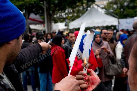 14 janvier 2017 : de jeunes tunisiens brulent un drapeau du parti Ennahdha. Les tunisiens fêtent dans une certaine morosité le 6ème anniversaire de la Révolution sur l'avenue Habib Bourguiba à Tunis. Peu de responsables politiques et d'organisations ont célébré samedi en Tunisie le 6e anniversaire de la révolution du 14 janvier 2011, alors qu'un certain désenchantement se manifeste à travers le pays.