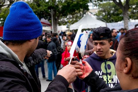 14 janvier 2017 : de jeunes tunisiens brulent un drapeau du parti Ennahdha. Les tunisiens fêtent dans une certaine morosité le 6ème anniversaire de la Révolution sur l'avenue Habib Bourguiba à Tunis. Peu de responsables politiques et d'organisations ont célébré samedi en Tunisie le 6e anniversaire de la révolution du 14 janvier 2011, alors qu'un certain désenchantement se manifeste à travers le pays.