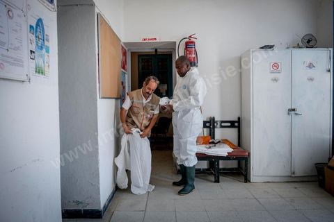 11 juin 2017 : Chemseddine Marzoug et Mohamed Trabelsi dans le local du croissant rouge tunisien de Zarzis s'équipent de leur tenue pour récupérer les corps de migrants. A Zarzis, sur le littoral tunisien, frontalier de la Libye, Chemseddine Marzoug, ancien pêcheur au chomage, offre bénévolement depuis 10 ans une sépulture de sable aux noyés de la Méditerranée. Bénévoles pour le croissant rouge tunisien Chemseddine et son collègue Mohamed Trabelsi enterrent depuis 10 ans les corps des migrants trouvés en mer ou échoués sur les plages du sud tunisien dans un cimetière improvisé dans une décharge municipale. En cette saison de printemps, les morts sont très nombreux 27 corps ont été repêchés ce dernier mois. 