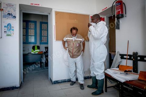 11 juin 2017 : Chemseddine Marzoug et Mohamed Trabelsi dans le local du croissant rouge tunisien de Zarzis s'équipent de leur tenue pour récupérer les corps de migrants. A Zarzis, sur le littoral tunisien, frontalier de la Libye, Chemseddine Marzoug, ancien pêcheur au chomage, offre bénévolement depuis 10 ans une sépulture de sable aux noyés de la Méditerranée. Bénévoles pour le croissant rouge tunisien Chemseddine et son collègue Mohamed Trabelsi enterrent depuis 10 ans les corps des migrants trouvés en mer ou échoués sur les plages du sud tunisien dans un cimetière improvisé dans une décharge municipale. En cette saison de printemps, les morts sont très nombreux 27 corps ont été repêchés ce dernier mois. 