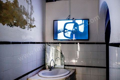 October 4, 2017: Dream City, Tunis Medina. Video installation by 
Fakhri el Ghezal titled “Héni éltéli”: “Wherever it falls, Fakhri El Ghezal’s gaze lends its solitude to more than one image. This video project unfolds, from one screen to the next, like so many variations on a single theme: drawing from everyday life, the videographer has decided to explore, day by day and without giving it too much thought, the realms of the intimate and the fictional. Armed with his cell phone, he captures—in varying durations—what passes by, comes to be, and unravels before his eyes. Between the routine and the isolation to which his well-oiled routine confines him; between death, which suddenly intrudes upon this daily life, and the grieving process that begins, certain threads of the artist’s post-prison experience replay in a loop. Bathed in black and white that yields as much to the present as to memory, Fakhri El Ghezal’s video work invites the viewer to keep their “third eye” open.”
