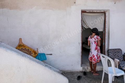 24 juin 2017 : Chez Océane, migrante Ivoirienne à Tunis dans un quartier populaire. Elle vit dans une maison avec 2 chambres qu'elle partage avec son fils Eden et cinq autres ivoiriennes. Océane est arrivée en Tunisie en 2010 comme étudiante et est depuis 5 ans en situation irrégulière, ne lui permettant plus de travailler légalement. Il y a deux ans Eden est né, ce jeune garçon plein de joie est devenu sa raison de vivre, elle souhaite trouver un endroit pour vivre normalement et élever son fils. “J’estime que pour vivre bien Tunisie, il me faudrait entre 800 et 1000 dinars. Généralement, je suis plutôt à 350. Entre les couches et la nourriture, les dépenses sont rapides.” La jeune femme travaille de façon irrégulière : elle a quelques patrons qui l’appellent, selon leur besoin, pour faire le ménage chez eux. Une journée lui rapporte entre 25 et 30 dinars.  