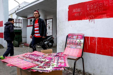February 18, 2018: In front of Parc A, Club Africain’s training center, fans are buying merchandise on the street before heading to the stadium. In Tunis, it’s the big day—the soccer derby, the match between the league’s two current top teams and Tunis’s two flagship clubs, Club Africain (CA) versus Espérance de Tunis (EST), at the Radès Stadium in the southern suburbs of Tunis. This rematch favors CA, which controls ticket sales. Given the numerous clashes between fans and ultra groups in the stadiums—both among themselves and with the police— only 23,000 tickets are being sold (out of a capacity of 60,000), including 1,200 for EST—though only about 50 of those will be in the south stand. The match will end with a surprise 2–1 victory for CA. 