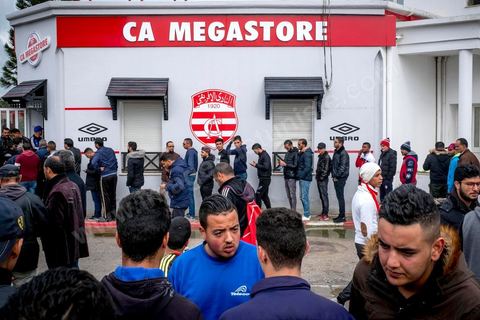February 18, 2018: At CA’s Park A, fans gather to make their final purchases of banners and scarves before heading to the stadium for the game. In Tunis, it’s the big day—the soccer derby, the match between the league’s two current top teams and Tunis’s two flagship clubs, Club Africain (CA) versus Espérance de Tunis (EST), at the Grand Stadium of Radès in the southern suburbs of Tunis. This rematch favors CA, which controls ticket sales. Given the numerous clashes between fans and ultra groups in the stadiums—both among themselves and with the police— only 23,000 tickets are being sold (out of a capacity of 60,000), including 1,200 for EST—though only about 50 of those will be in the south stand. The match will end with a surprise 2–1 victory for CA. 