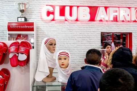 February 18, 2018: At CA’s Park A, fans gather to make their final purchases of banners and scarves before heading to the stadium for the game. In Tunis, it’s the big day—the soccer derby, the match between the league’s two current top teams and Tunis’s two flagship clubs, Club Africain (CA) versus Espérance de Tunis (EST), at the Grand Stadium of Radès in the southern suburbs of Tunis. This rematch favors CA, which controls ticket sales. Given the numerous clashes between fans and ultra groups in the stadiums—both among themselves and with the police— only 23,000 tickets are being sold (out of a capacity of 60,000), including 1,200 for EST—though only about 50 of those will be in the south stand. The match will end with a surprise 2–1 victory for CA. 