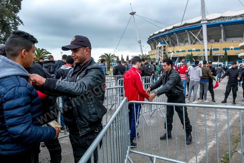 February 18, 2018: Entry to the stadium—and specifically access to the north stands, where the CA ultras are located—requires discipline, as well as police checks and searches. Since recent matches have seen a great deal of violence and clashes between ultras and the police, entry procedures to the stadium are strict and overseen by nearly 3,000 police officers. In Tunis, it’s the big day—the soccer derby, the match between the two current top teams in the league and Tunis’s two flagship teams, Club Africain (CA) versus Espérance de Tunis (EST), at the Radès Stadium in the southern suburbs of Tunis. CA holds the advantage in this rematch, as it controls ticket sales. Given the numerous clashes between fans and ultra groups—both among themselves and with the police—inside the stadiums, only 23,000 tickets are being sold (out of a capacity of 60,000), including 1,200 for EST—though only about 50 of those will be in the south stands. The match will end with a surprise 2–1 victory for CA. 