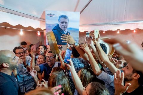 15 septembre 2019 : au QG du parti de Nabil Karoui, candidat en prison à l'election présidentielle en Tunisie, les militants fêtent le passage au second tour selon les sondages, Nabil Karoui serait en deuxième position derrière le candidat surprise Kais Saïed. Ce premier tour marque la victoire de candidat indépendant et populiste, dévant de loin les candidats dits "progressistes" représnetant l'ancien sytéme et le candidat du parti islamiste Ennahdha. 