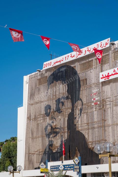Au centre ville l'immense portrait en lamellles de Mohamed Bouaziz trone toujours sur la poste, avec la charrette, ces derniers signes du "martyr" qui a déclenché la révolution vieillisent mal. Sidi Bouzid, 10 ans après la révolution le bilan. Il y a 10 ans, le 17 décembre 2010, Mohamed Bouazizi, jeune chomeur, vendeur ambulant de légumes, s'immolait devant le gouvernorat au centre ville. Ce fut le début des manifestations des syndicalistes en région, le début de la révolution tunisienne qui aboutira le 14 janvier 2011 au départ du président dictateur Ben Ali et de sa famille. "Travail, Liberté et Dignité", ces trois mots du slogan des révolutionnaires de 2010 sont encore et toujours aujourd'hui scandés dans les rues de Tunisie. 