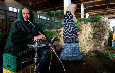 Vendeur fumant la chicha à la Halle aux fruits et légumes du marché de gros de Tunis à El Mourouj
