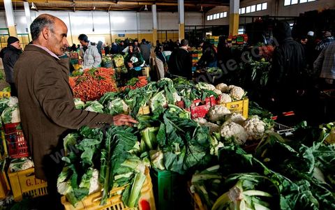 Vendeur et étales de choux et carottes à la Halle aux fruits et légumes du marché de gros de Tunis à El Mourouj