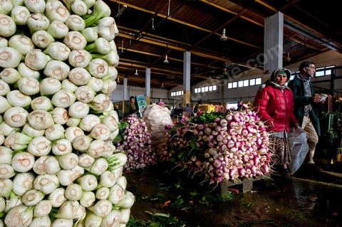 Vendeur et étales de radis et oignons à la Halle aux fruits et légumes du marché de gros de Tunis à El Mourouj