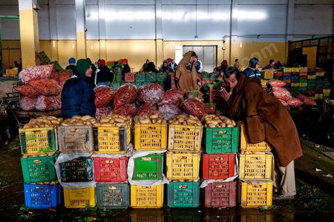Vendeur et étales de pommes de terre et carottes à la Halle aux fruits et légumes du marché de gros de Tunis à El Mourouj
