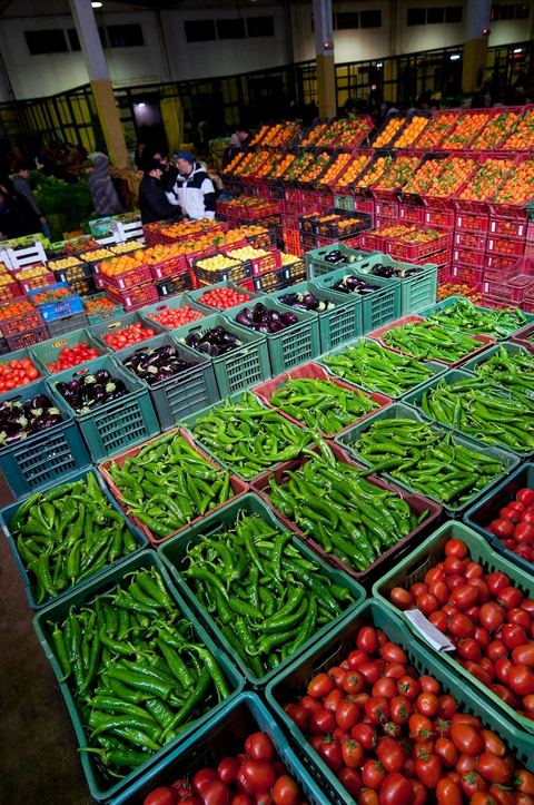 Etale et vendeurs de tomates, poivrons et oranges à la Halle aux fruits et légumes du marché de gros de Tunis à El MouroujHalle aux fruits et légumes du marché de gros de Tunis à El Mourouj