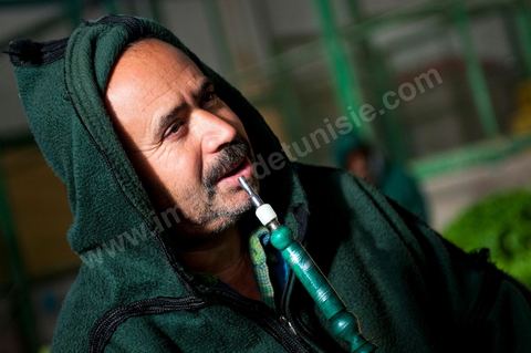 Vendeur fumant la chicha à la Halle aux fruits et légumes du marché de gros de Tunis à El Mourouj
