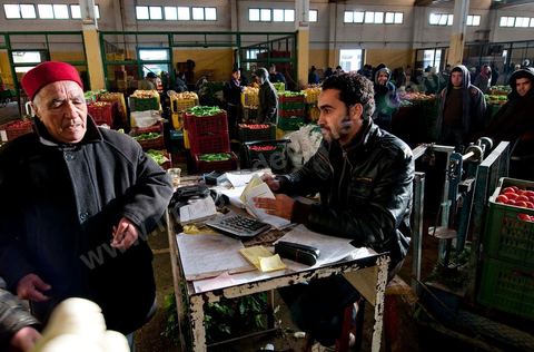 Vendeur faisant ses comptes à la Halle aux fruits et légumes du marché de gros de Tunis à El Mourouj