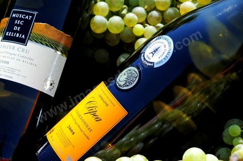 Bottles of dry Muscat white wine from Kelibia and Clipea Chardonnay were displayed among clusters of white grapes in the heart of the Kelibia vineyard