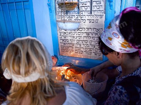 Pelerins juifs déposant des cierges et priant dans une petite synagogue bleue à Hara Sghira Erriadh durant le pelerinage juif annuel au village de Erriadh ou Hara Sghira sur l'ile de djerba