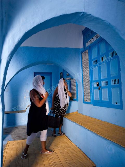 Pelerins juifs déposant des cierges et priant dans une petite synagogue bleue à Hara Sghira Erriadh durant le pelerinage juif annuel au village de Erriadh ou Hara Sghira sur l'ile de djerba