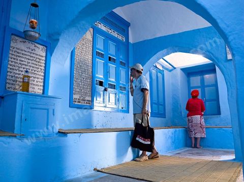 Pelerins juifs déposant des cierges et priant dans une petite synagogue bleue à Hara Sghira Erriadh durant le pelerinage juif annuel au village de Erriadh ou Hara Sghira sur l'ile de djerba
