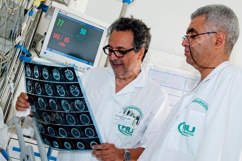 Le Dr Tahar Khalfallah (premier plan), chirurgien, et le Dr Mohamed Salah Ben Ammar (au second plan), anesthésiste, durant une consultation auprès d'un patient au service réanimation à l'hopital Mongi Slim de la Marsa