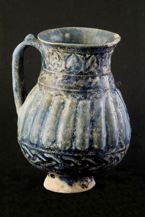 PICHET MOULÉIraq ou Perse, époque abbaside, 8  - 9  siècle.Cette céramique moulée à la panse cannelée et au col muni d'anneaux dérive directementd'un modèle en métal.