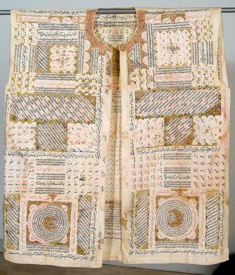 CHEMISE TALISMANIQUE 'HIRZ'Empire ottoman, 17  siècle.Il était d'usage chez les dignitaires ottomans et leurs enfants de porter, en cas de maladie et à titre prophylactique, des gilets et des bonnets coupés dans des reliques provenant des tentures intérieures de la Kaaba ou du mausolée du prophète Mohammad à Médine. Portée pour se parer contre les risques en tous genres, maladie, envoûtement, blessure de guerre, la chemise exposée ici fait partie d'une série rare. Le palais de Topkapi à Istanbul en conserve quelques unes ayant appartenues au sultan. Sa confection doit respecter plusieurs paramètres. Pour être portée à même la peau, elle est généralement taillée dans un tissu fin et dessinée avec des pigments spéciaux. Interviennent alors les techniques d'un ensemble de spécialistes des sciences occultes et ésotériques : oniromanciens, astrologues et numérologues. Ces chemises sont généralement ornées de nombreuses références coraniques, de prières, de convocation des esprits, de formules talismaniques et de figures géométriques, en rond, carré, pyramide, rectangle, ellipse, arc, ayant chacune sa propre valeur numérique. Initiée par les premiers alchimistes, puis par les Frères de la pureté, philosophes pythagoriciens et néo-platoniciens du 10   siècle, la valeur numérique des lettres est devenue l'objet d'une véritable science, jusqu'à aboutir à la formation d'une confrérie mystique lettriste, 'La Houroufia'. Le pouvoir ottoman tentera sa liquidation dès le 16  siècle craignant ses pouvoirs surnaturels, ses prétentions politiques et son syncrétisme religieux associant judaïsme, chrétienté et Islam. Des traces de la Houroufia marqueront certains dogmes de la confrérie Bektachia, naguère suivie à Sidi el-Bektachi à Tunis, par les janissaires (soldats ottomans, anciens esclaves d'origine européenne).