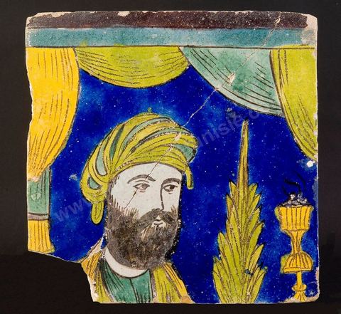 CARREAU AU PORTRAIT.Perse safavide, 17 -  18  siècle.Traits réalistes caractéristiques de la manière safavide. D'introduction récente dans l'art oriental, le réalisme s'est manifesté d'abord en Perse au 16   siècle, au moment où l'image (la miniature) a triomphé de la calligraphie et s'est réalisée en tant qu'image indépendante de l'ouvrage.À l'origine de ce mouvement, la fascination qu'exerce la peinture européenne.cost