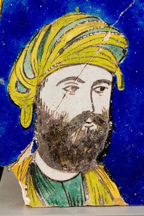 CARREAU AU PORTRAIT.Perse safavide, 17 -  18  siècle.Traits réalistes caractéristiques de la manière safavide. D'introduction récente dans l'art oriental, le réalisme s'est manifesté d'abord en Perse au 16   siècle, au moment où l'image (la miniature) a triomphé de la calligraphie et s'est réalisée en tant qu'image indépendante de l'ouvrage.À l'origine de ce mouvement, la fascination qu'exerce la peinture européenne.cost