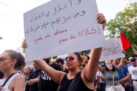 Tunis, Tunisie – 20 août 2026. Des manifestants défilent dans le centre de Tunis contre le président Kaïs Saïed, appelant à son départ et réclamant davantage de libertés politiques et la libération de détenus et opposants. Portraits du président barrés du slogan « DÉGAGE », drapeaux tunisiens et pancartes accompagnent la manifestation. La mobilisation intervient dans un contexte de mécontentement social croissant après plusieurs semaines de fortes chaleurs, de coupures d’eau et d’électricité et de difficultés d’accès à certains médicaments et produits essentiels.