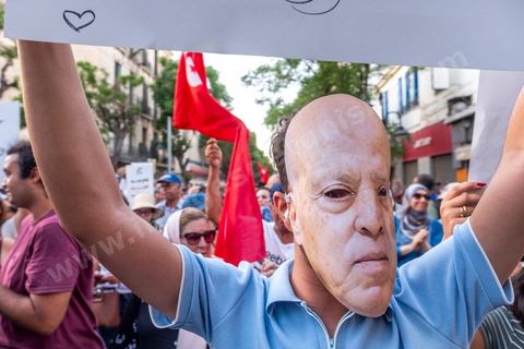 Tunis, Tunisie – 20 août 2026. Des manifestants défilent dans le centre de Tunis contre le président Kaïs Saïed, appelant à son départ et réclamant davantage de libertés politiques et la libération de détenus et opposants. Portraits du président barrés du slogan « DÉGAGE », drapeaux tunisiens et pancartes accompagnent la manifestation. La mobilisation intervient dans un contexte de mécontentement social croissant après plusieurs semaines de fortes chaleurs, de coupures d’eau et d’électricité et de difficultés d’accès à certains médicaments et produits essentiels.
