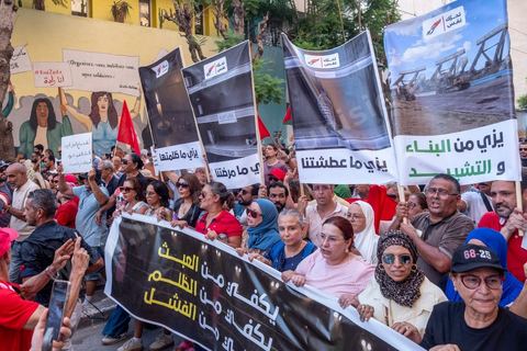 Tunis, Tunisie – 20 août 2026. Des manifestants défilent dans le centre de Tunis contre le président Kaïs Saïed, appelant à son départ et réclamant davantage de libertés politiques et la libération de détenus et opposants. Portraits du président barrés du slogan « DÉGAGE », drapeaux tunisiens et pancartes accompagnent la manifestation. La mobilisation intervient dans un contexte de mécontentement social croissant après plusieurs semaines de fortes chaleurs, de coupures d’eau et d’électricité et de difficultés d’accès à certains médicaments et produits essentiels.