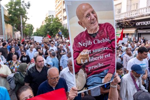 Tunis, Tunisie – 20 août 2026. Des manifestants défilent dans le centre de Tunis contre le président Kaïs Saïed, appelant à son départ et réclamant davantage de libertés politiques et la libération de détenus et opposants. Portraits du président barrés du slogan « DÉGAGE », drapeaux tunisiens et pancartes accompagnent la manifestation. La mobilisation intervient dans un contexte de mécontentement social croissant après plusieurs semaines de fortes chaleurs, de coupures d’eau et d’électricité et de difficultés d’accès à certains médicaments et produits essentiels.