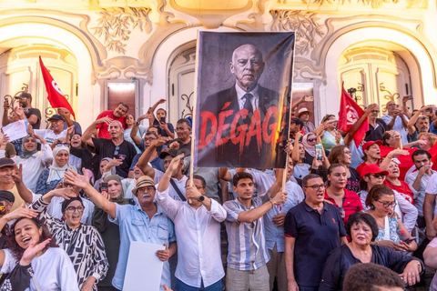 Tunis, Tunisie – 20 août 2026. Des manifestants défilent dans le centre de Tunis contre le président Kaïs Saïed, appelant à son départ et réclamant davantage de libertés politiques et la libération de détenus et opposants. Portraits du président barrés du slogan « DÉGAGE », drapeaux tunisiens et pancartes accompagnent la manifestation. La mobilisation intervient dans un contexte de mécontentement social croissant après plusieurs semaines de fortes chaleurs, de coupures d’eau et d’électricité et de difficultés d’accès à certains médicaments et produits essentiels.