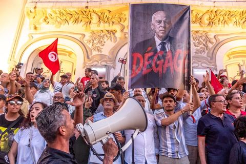 Tunis, Tunisie – 20 août 2026. Des manifestants défilent dans le centre de Tunis contre le président Kaïs Saïed, appelant à son départ et réclamant davantage de libertés politiques et la libération de détenus et opposants. Portraits du président barrés du slogan « DÉGAGE », drapeaux tunisiens et pancartes accompagnent la manifestation. La mobilisation intervient dans un contexte de mécontentement social croissant après plusieurs semaines de fortes chaleurs, de coupures d’eau et d’électricité et de difficultés d’accès à certains médicaments et produits essentiels.