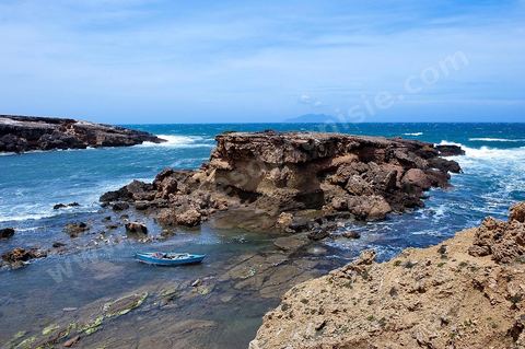 La côte d'El Haouaria à la pointe du Cap Bon, falaise, mer et montagnes. Baie avec plage et barques de pêcheurs.