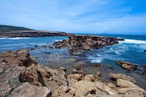 La côte d'El Haouaria à la pointe du Cap Bon, falaise, mer et montagnes. Baie avec plage et barques de pêcheurs.